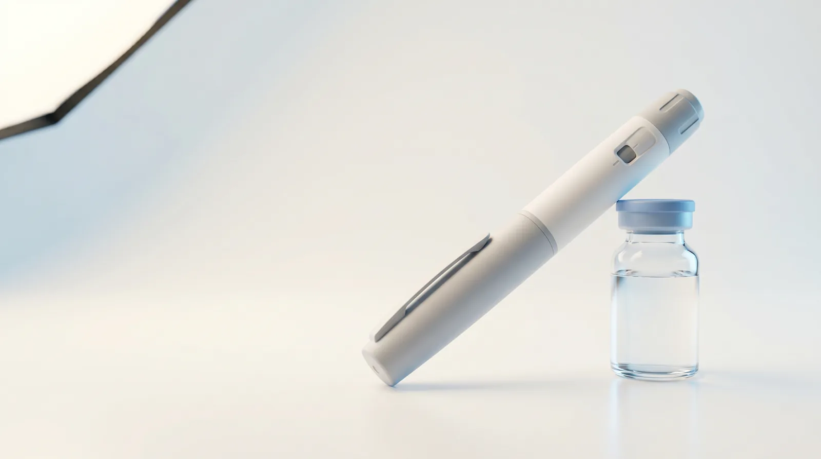 A semaglutide injector pen beside a clear pharmacy vial on a clean studio surface